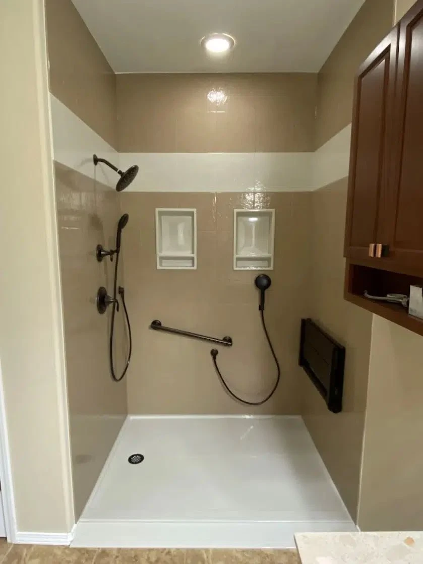 ADA walk-in shower with oil-rubbed bronze multi-head fixtures, dual niches, grab bar and handheld sprayer for aging-in-place