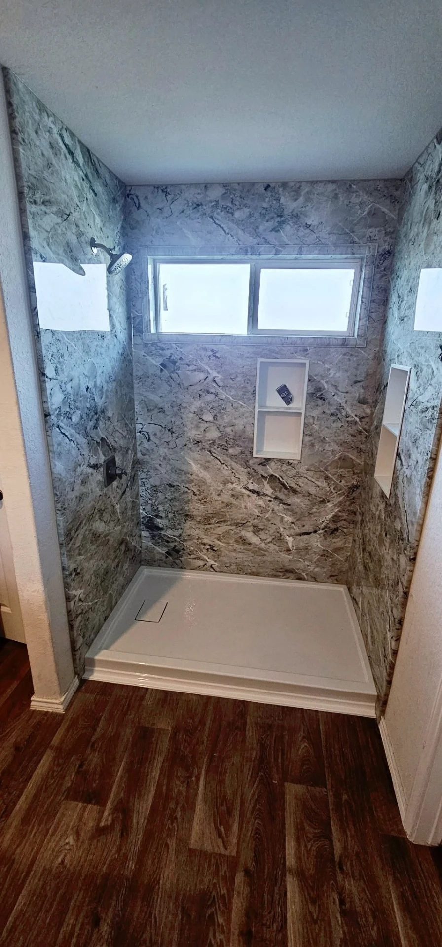 Custom Onyx walk-in shower with blue marble-pattern walls, double recessed niches and a low-profile shower pan installed in a San Antonio bathroom