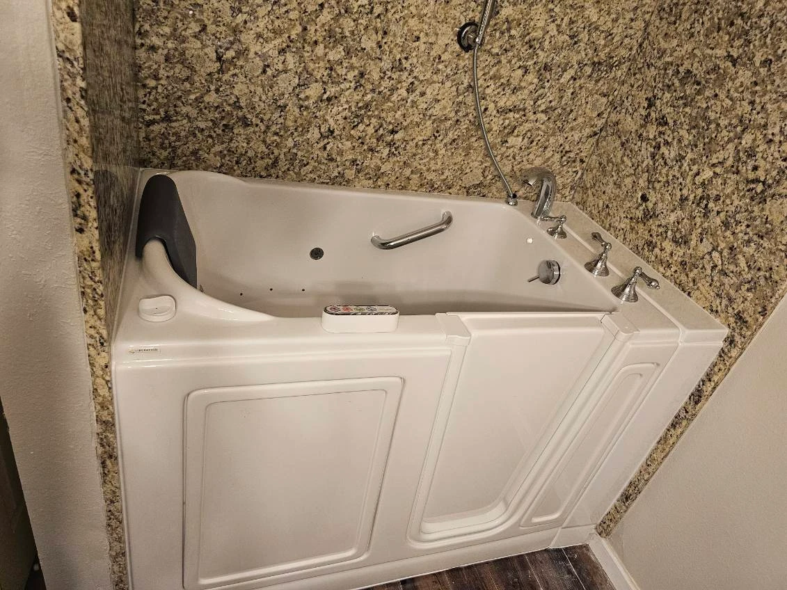 Step-in walk-in tub with hydrotherapy jets, chrome handheld and granite tub deck — built for safe, independent bathing